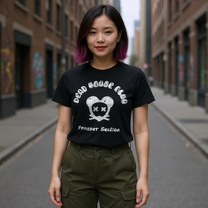 Könnte beinhalten: Schwarzes T-Shirt mit dem Text "DEAD HOUSE CLUB" und einer Maus-Kopf-Grafik mit X-förmigen Augen. Die Worte "Freezer Section" stehen darunter. Die Person trägt eine olivgrüne Cargohose.