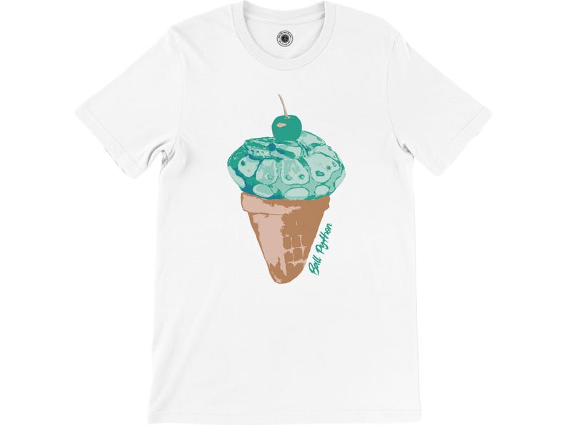 K&ouml;nnte beinhalten: Wei&szlig;es T-Shirt mit einer skurrilen Grafik. Es zeigt eine Eist&uuml;te mit einer t&uuml;rkisfarbenen Kugel und einer Kirsche. Die Waffel ist braun, und der Text "Ball Python" ist in T&uuml;rkis geschrieben.