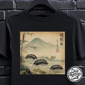 May include: Black t-shirt with a Japanese-style illustration of pill bugs, a mountain, and bamboo. The design includes Japanese characters and a red seal. The shirt also has a "Cold Blooded Club" logo.