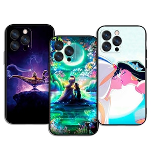 Puede incluir: Tres fundas para teléfono con ilustraciones coloridas. Una funda presenta una lámpara dorada con humo sobre un fondo púrpura. Otra representa a una pareja en un lago bajo la luna llena. La tercera muestra a una pareja besándose.