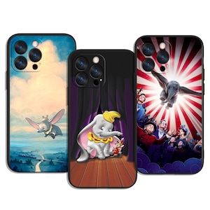 Könnte beinhalten: Drei Handyhüllen mit Dumbo-Designs. Eine Hülle zeigt Dumbo beim Fliegen in einem blauen Himmel, eine andere zeigt Dumbo auf einer Bühne und die dritte zeigt Dumbo in einem Zirkus mit rotem und weißem Hintergrund.