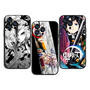 Può includere: Tre custodie per telefono con personaggi anime. La custodia a sinistra presenta un'illustrazione in bianco e nero di un personaggio con capelli infuocati. La custodia centrale ha un'illustrazione colorata con il testo "Demon Slayer". La custodia a destra presenta un personaggio con una spada.