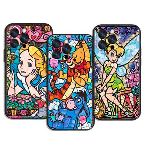 May include: Three phone cases with stained glass designs featuring Disney characters. One case features Alice in Wonderland, another Winnie the Pooh and friends, and the third Tinkerbell. Each case has a black border and a colourful, detailed design.