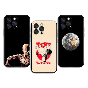 Può includere: Tre custodie per telefono con diversi design. Una custodia è nera con la grafica di una figura calva e muscolosa. Un'altra è beige con un cerchio rosso e testo giapponese. La terza è nera con una luna e una figura in tuta gialla.