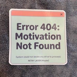 May include: A square sticker with a light green background and a coral-coloured top bar featuring an X icon. The text reads: Error 404: Motivation Not Found. Below this, smaller text states: System could not locate any drive to proceed. RETRY LATER (Maybe).