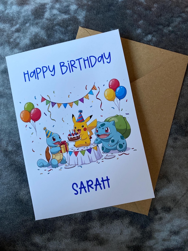K&ouml;nnte beinhalten: Eine wei&szlig;e Geburtstagskarte mit dem Text "HAPPY BIRTHAY SARAH" in Blau. Die Karte zeigt Cartoonfiguren, Luftballons, Konfetti und einen Kuchen. Ein brauner Umschlag befindet sich hinter der Karte.