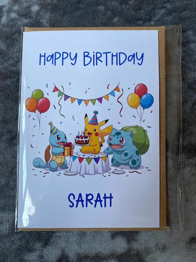 K&ouml;nnte beinhalten: Geburtstagskarte mit dem blauen Schriftzug "Happy Birthday Sarah". Die Karte zeigt eine farbenfrohe Illustration von Pikachu, Schiggy und Bisasam an einem Tisch mit Kuchen und Luftballons.