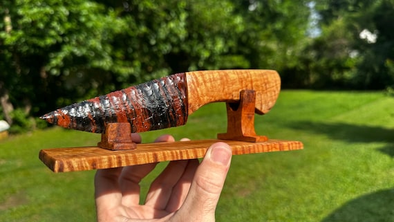 A Cherokee Nation artist hand-knaps razor-sharp obsidian flakes into a knife blade and sets it in a stunning spalted curly maple handle — this is 10,000-year-old stone-age technology executed as fine art.