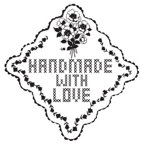 Puede incluir: Una etiqueta en forma de diamante en blanco y negro con el texto "HANDMADE WITH LOVE" en un estilo de punto de cruz. La etiqueta est&aacute; enmarcada con un borde floral y un ramo de flores en la parte superior.