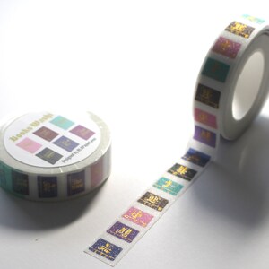 K&ouml;nnte beinhalten: Eine Rolle Washi-Tape mit wei&szlig;em Hintergrund und bunten Buchumschl&auml;gen mit goldenen Schriftz&uuml;gen. Das Band tr&auml;gt die Aufschrift "Books to Wrap" und "Designed by Paper Love".