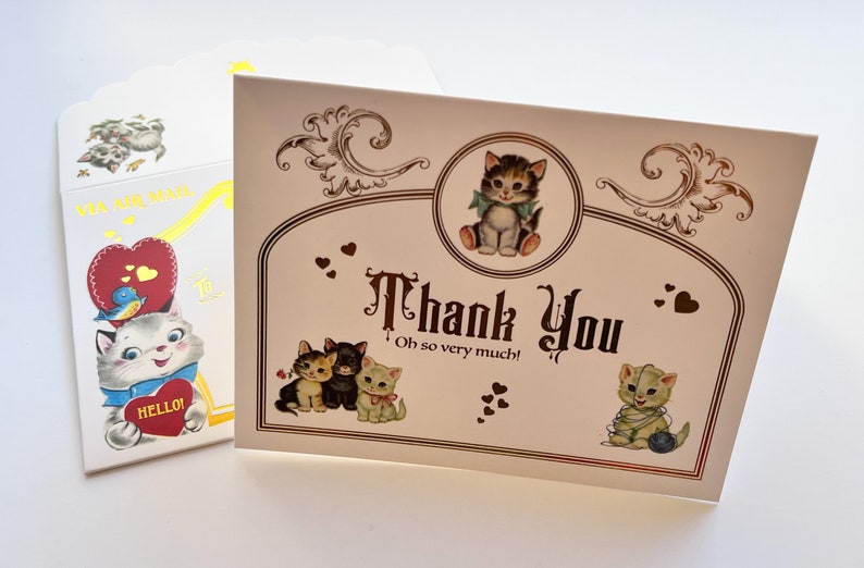 Puede incluir: Un juego de tarjetas de felicitaci&oacute;n de estilo vintage con tem&aacute;tica de gatos. La tarjeta principal dice "Thank You" con ilustraciones de gatitos. El sobre presenta un gato y las palabras "Via Air Mail". La paleta de colores incluye crema, marr&oacute;n, rojo y azul.