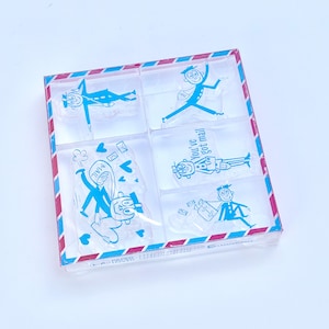 May include: A set of clear stamps with blue cartoon mail carrier designs. The stamps are in a clear plastic box with a red and blue striped border. The stamps feature images of mail carriers, mailboxes, and the text "You've got mail".