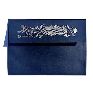 May include: A navy blue envelope with a silver foil design. The design includes a bird, floral elements, and text that reads "Not delivered in ten days return to sender" and "LAFAYETTE LOVES". The envelope is on a white background.