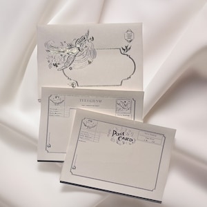 Puede incluir: Un conjunto de tres tarjetas de papeler&iacute;a en blanco de estilo vintage con bordes decorativos y un dise&ntilde;o de p&aacute;jaro. Las tarjetas est&aacute;n etiquetadas como "Telegrama", "Tarjeta postal" y "Ponga un sello aqu&iacute;".