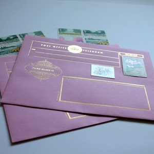 Może przedstawiać: Dwie mauve koperty telegram&oacute;w ze złotymi akcentami i ozdobnymi znaczkami pocztowymi. Na kopertach widnieją napisy "Post Office Telegram" i "Please Deliver To". Widocznych jest kilka znaczk&oacute;w.