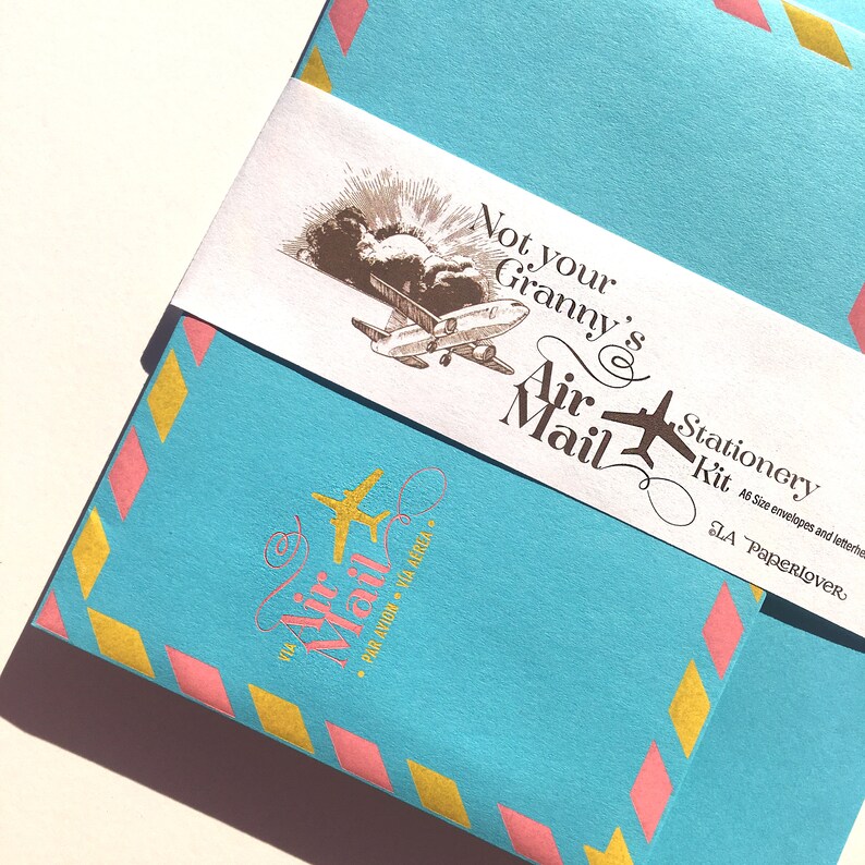 May include: A blue and pink stationery kit with a gold airplane design and the text "Not your Granny's Air Mail Stationery Kit. A5 Size envelopes and letterheads. LA Paperlover."