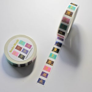 K&ouml;nnte beinhalten: Eine Rolle wei&szlig;es Washi-Klebeband mit einem bunten Design aus geschlossenen B&uuml;chern mit goldenen Schriftz&uuml;gen. Das Band ist mit "Booko Washi" und "Designed by LL Magazine" beschriftet.