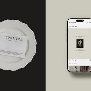 Puede incluir: Un plato blanco con borde festoneado con un papel doblado que muestra el texto "LE NEUTRE". Un smartphone a la derecha muestra una publicaci&oacute;n de Instagram con un gr&aacute;fico de concha y el texto "ATELIER NEUTRE".