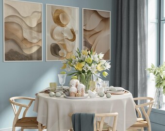 Könnte beinhalten: Esszimmer-Szene mit einem runden Tisch, der für eine Mahlzeit gedeckt ist. Der Tisch ist mit einer cremefarbenen Tischdecke bedeckt und mit Tellern, Gläsern und Osterdekorationen gedeckt. Drei abstrakte Kunstwerke hängen an der blauen Wand über dem Tisch.