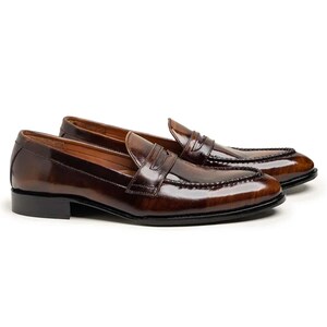 May include: A pair of brown leather penny loafers. The shoes have a glossy finish and a classic design, featuring a strap across the vamp. The soles are black, and the shoes are set against a white background. The shoes are a size 10.