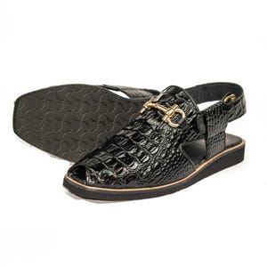 Op de afbeelding: Zwarte leren sandalen met een krokodillenstructuur. De sandalen hebben een goudkleurige gesp en een zwarte zool. Het open teenontwerp heeft een bandje om de enkel. De zool is ongeveer 2,5 cm dik.
