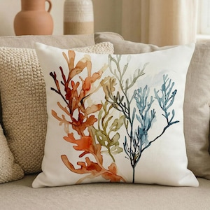 May include: A white ceramic mug with a black handle and the text "But First, Coffee" in a bold, black font. The mug is set against a blurred background, highlighting its clean design.