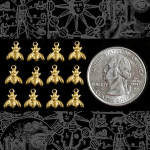 May include: Twelve gold-colored bee charms, each approximately the size of a US quarter. The charms are arranged in four rows of three, with a quarter dollar coin for scale.