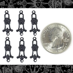 Pu&ograve; includere: Sei connettori in filigrana di metallo nero con un design floreale, ciascuno di circa 2,5 cm di lunghezza, sono esposti accanto a una moneta da un quarto di dollaro statunitense per il confronto delle dimensioni. I connettori hanno un anello nella parte superiore e un fondo decorativo.