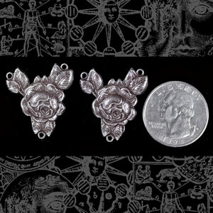 May include: Two silver-toned rose-shaped charms, each with three leaves. The charms have a loop at the top and two loops at the bottom. A US quarter is included for size reference.