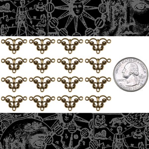 May include: A set of 15 antique gold-toned metal connector charms. Each charm features a delicate, ornate design with a central teardrop shape and two loops on either side. The charms are approximately the size of a US quarter.