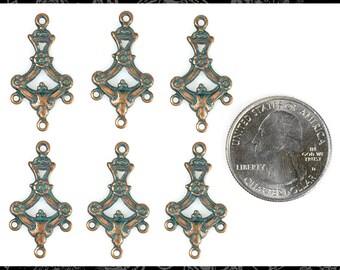May include: Six antique copper-toned metal charms with a green patina. Each charm features a decorative design with a floral motif. The charms are approximately the size of a US quarter.