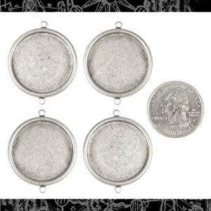 May include: Four silver-toned metal round pendant trays with a raised edge and three jump rings. The trays are approximately the size of a US quarter.