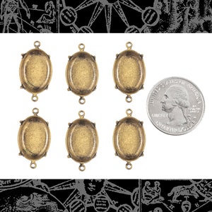 May include: Six antique gold oval-shaped pendant settings with two loops on the top. The settings are approximately the size of a US quarter.