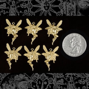 May include: Six gold-toned metal charms featuring a fairy design. Each charm has a loop at the top for attaching to a necklace or bracelet. The charms are arranged in two rows of three, with a quarter for scale.
