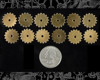 May include: Ten gold-colored metal gears with a slightly textured surface. The gears are arranged in three rows, with three gears in each row. The gears are approximately the size of a US quarter.