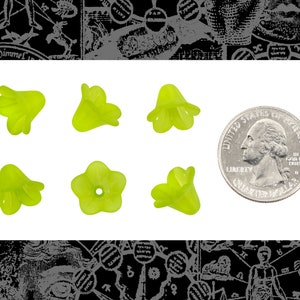 May include: Six lime green glass flower-shaped beads, each with five petals, next to a US quarter for size comparison.