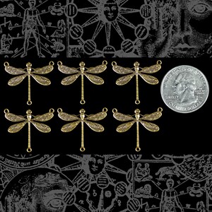 May include: Ten gold-toned dragonfly charms with intricate details. Each charm has a loop at the top for attaching to jewelry or other crafts.