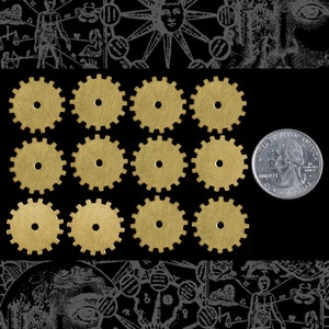 May include: A collection of twelve small, brass-colored gear wheels with a central hole, arranged on a black background. A U.S. quarter coin is included for size comparison. The gears have a steampunk aesthetic.