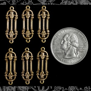 May include: Six gold-toned metal charms with a floral design. Each charm features a stylized rose with leaves and a vertical bar in the center. The charms are approximately the size of a US quarter.