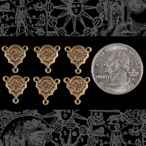 Könnte beinhalten: Sechs goldfarbene Metall-Verbindungsanhänger mit einem dekorativen floralen Design. Die Anhänger sind etwa so groß wie eine US-amerikanische 25-Cent-Münze.