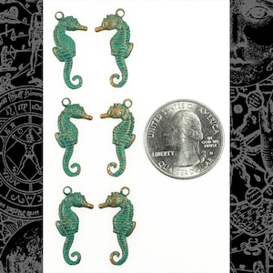 Puede incluir: Seis encantos de caballito de mar de bronce antiguo con un acabado de pátina verde. Los encantos son aproximadamente del tamaño de una moneda de 25 centavos de dólar estadounidense.