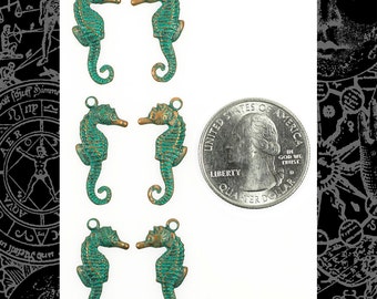 May include: Six antique bronze seahorse charms with a green patina finish. The charms are approximately the size of a US quarter.