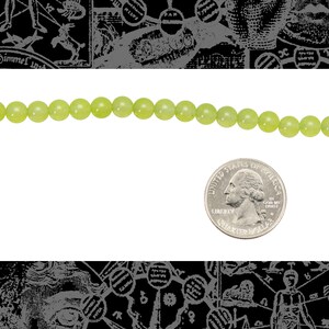 May include: A strand of light green jade beads, approximately the size of a US quarter.