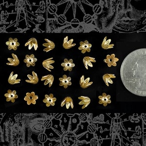 May include: A collection of 20 gold-colored metal flower-shaped bead caps. The bead caps are arranged in a grid pattern on a black surface. A US quarter is included for scale.