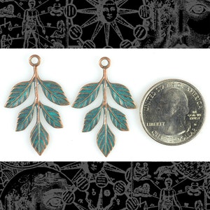 May include: Two antique copper leaf charms with a turquoise patina. The charms are approximately the size of a US quarter.