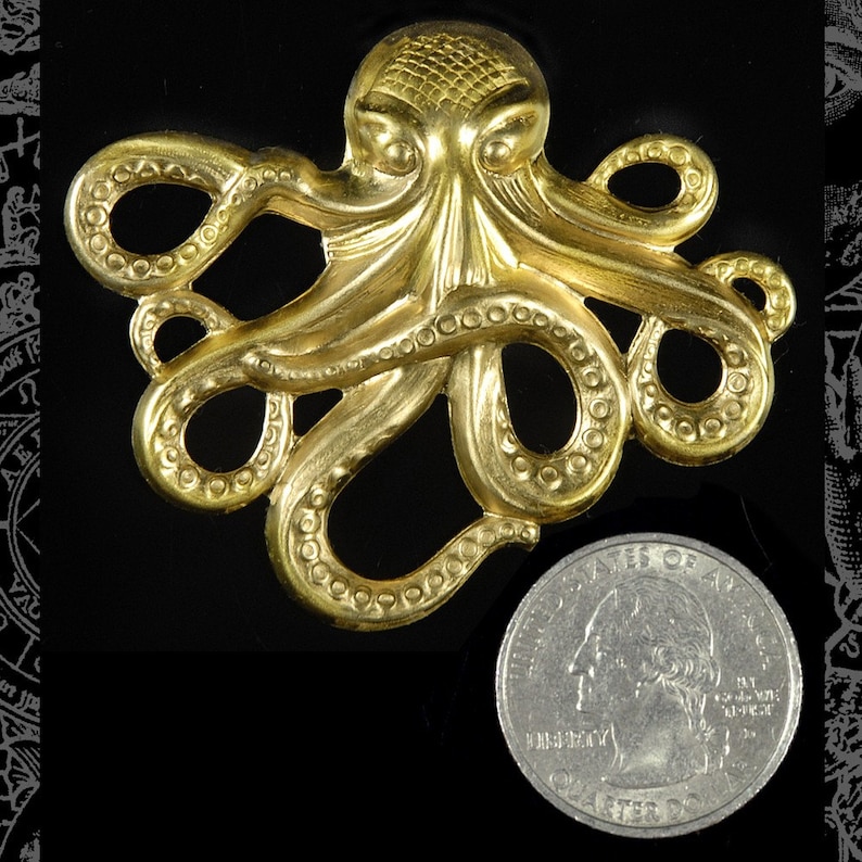 May include: A gold-colored metal octopus pendant with detailed tentacles and a textured surface. The pendant is about the size of a quarter.