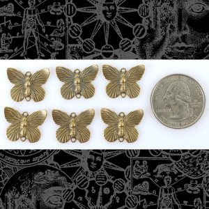 May include: Six antique gold-toned butterfly charms with a textured finish. The charms are approximately the size of a UK 20 pence coin.