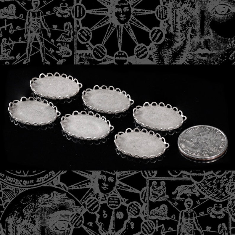 Puede incluir: Seis piezas ovaladas de metal plateadas con bordes festoneados. Las piezas est&aacute;n dispuestas en semic&iacute;rculo sobre una superficie negra. Una moneda de 25 centavos de d&oacute;lar estadounidense plateada se encuentra en la esquina inferior derecha de la imagen.