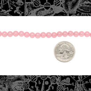 Peut inclure: Un brin de perles rondes roses, d'environ la taille d'une pi&egrave;ce de 25 cents am&eacute;ricaine.