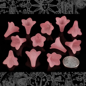 May include: Twelve pink flower-shaped glass beads with a frosted finish. The beads are approximately 1 inch in diameter.
